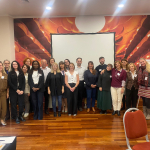 A group of people standing together and smiling at the camera