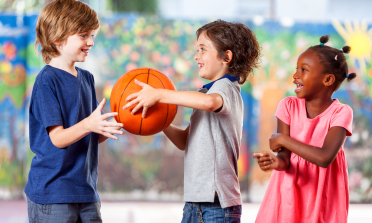Three children playing with a basketball